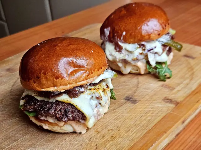 Dva burgery s čedarem na prkénku